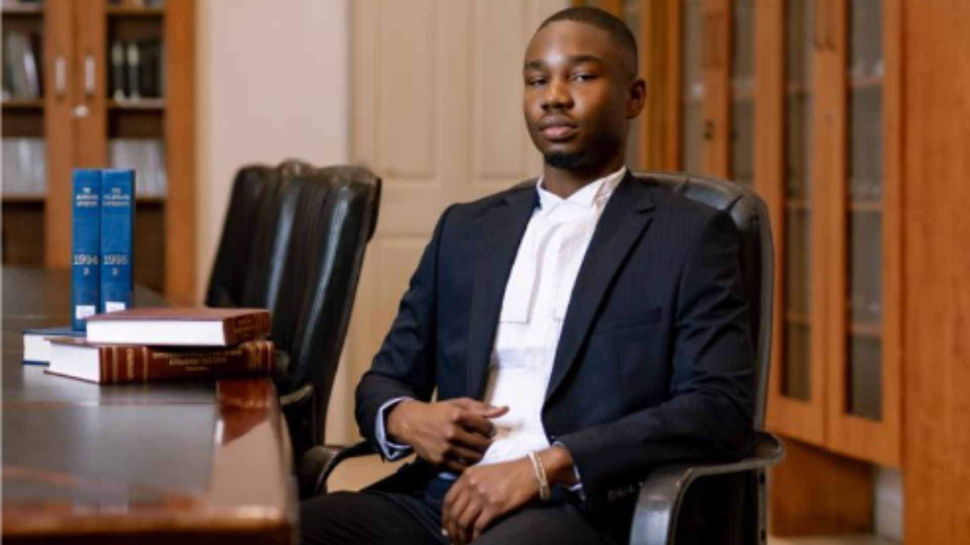 Farai Mudadi seated in a law library ahead of his admission to the Bar of the Supreme Court of Zambia