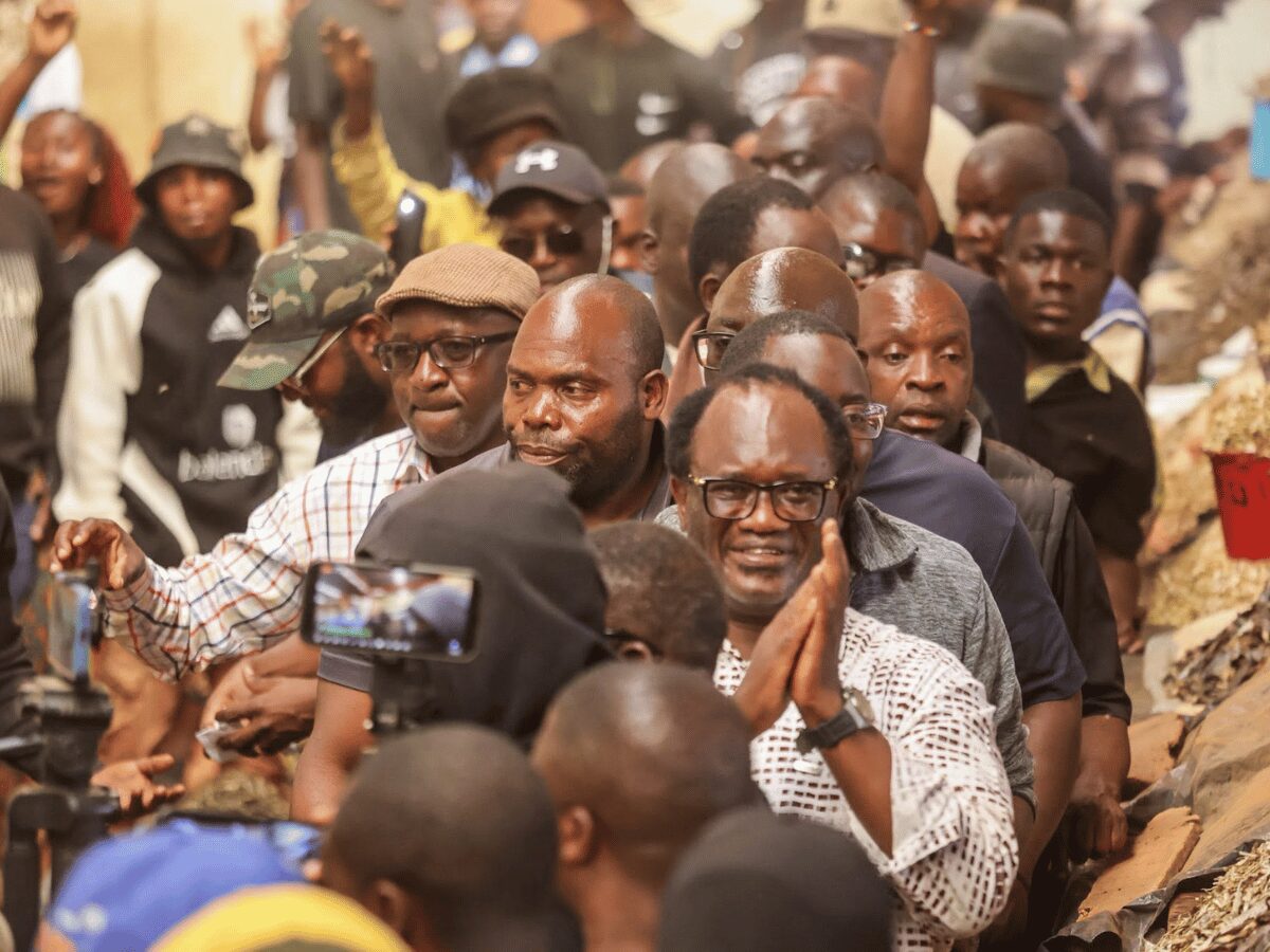 Brian Mundubile greets supporters while campaigning through a Lusaka compound