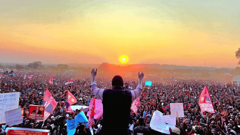 President Hakainde Hichilema raises his arms to a massive crowd of UPND supporters at sunrise, celebrating his re-election in Zambia's 2026 presidential poll