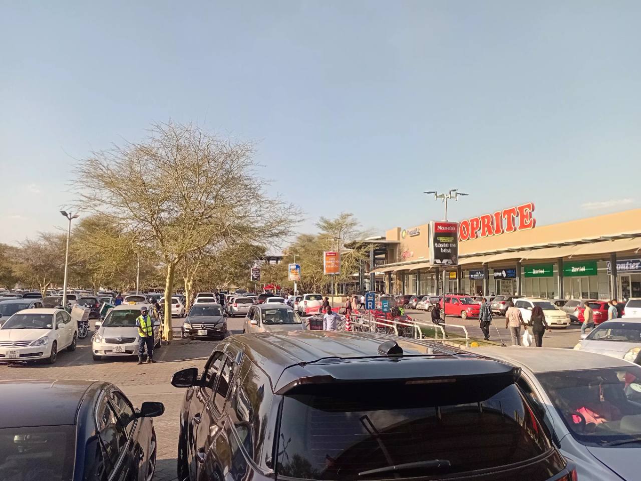 Shoppers and vehicles outside Shoprite at East Park Mall during a busy Sunday afternoon
