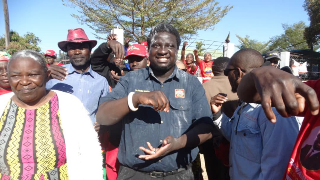 UPND supporters wearing red campaign attire gather outdoors during Imanga Wamunyima Jr's Nalolo parliamentary campaign