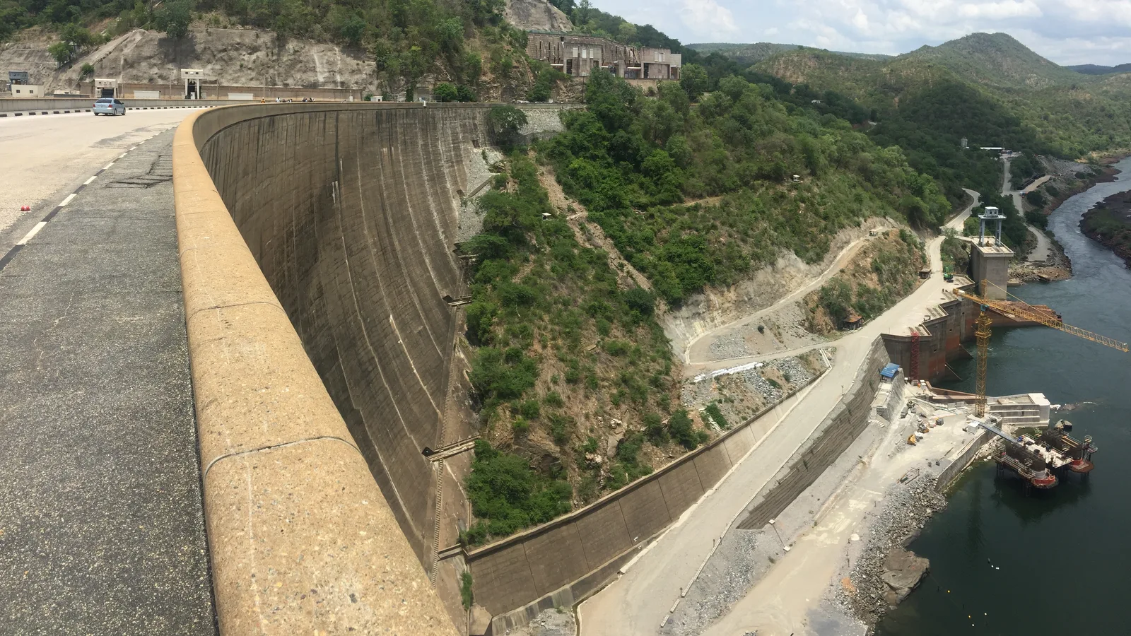 The curved concrete wall of Kariba Dam holding back the Zambezi River under a wide sky