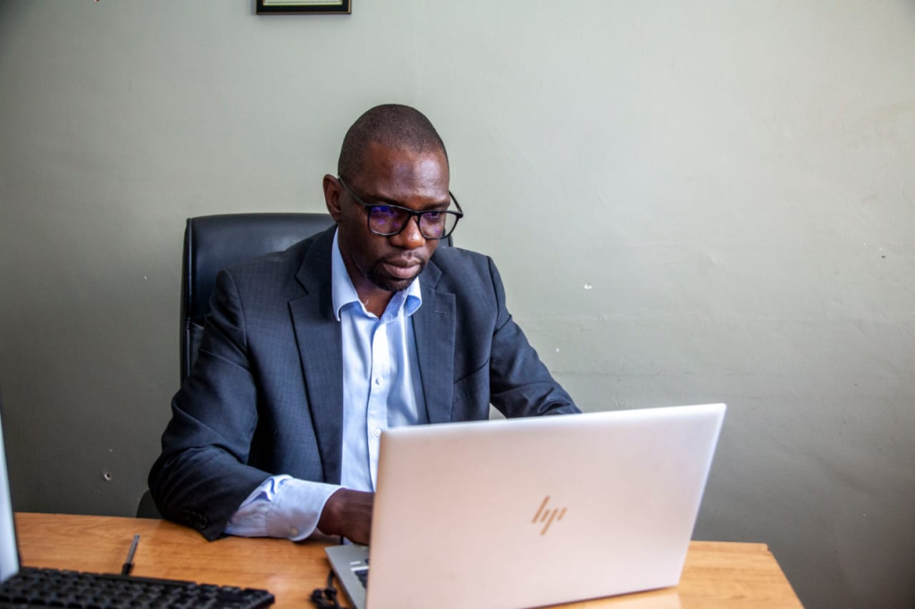 Economist Kelvin Chisanga working at a laptop