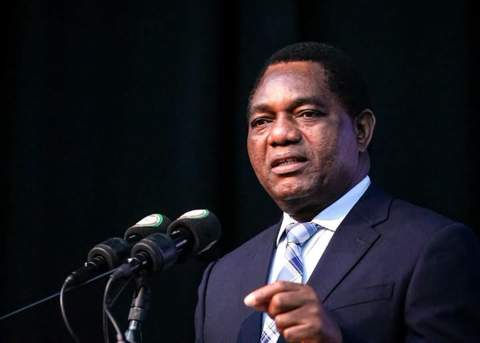 President Hakainde Hichilema speaking at a podium during a campaign address