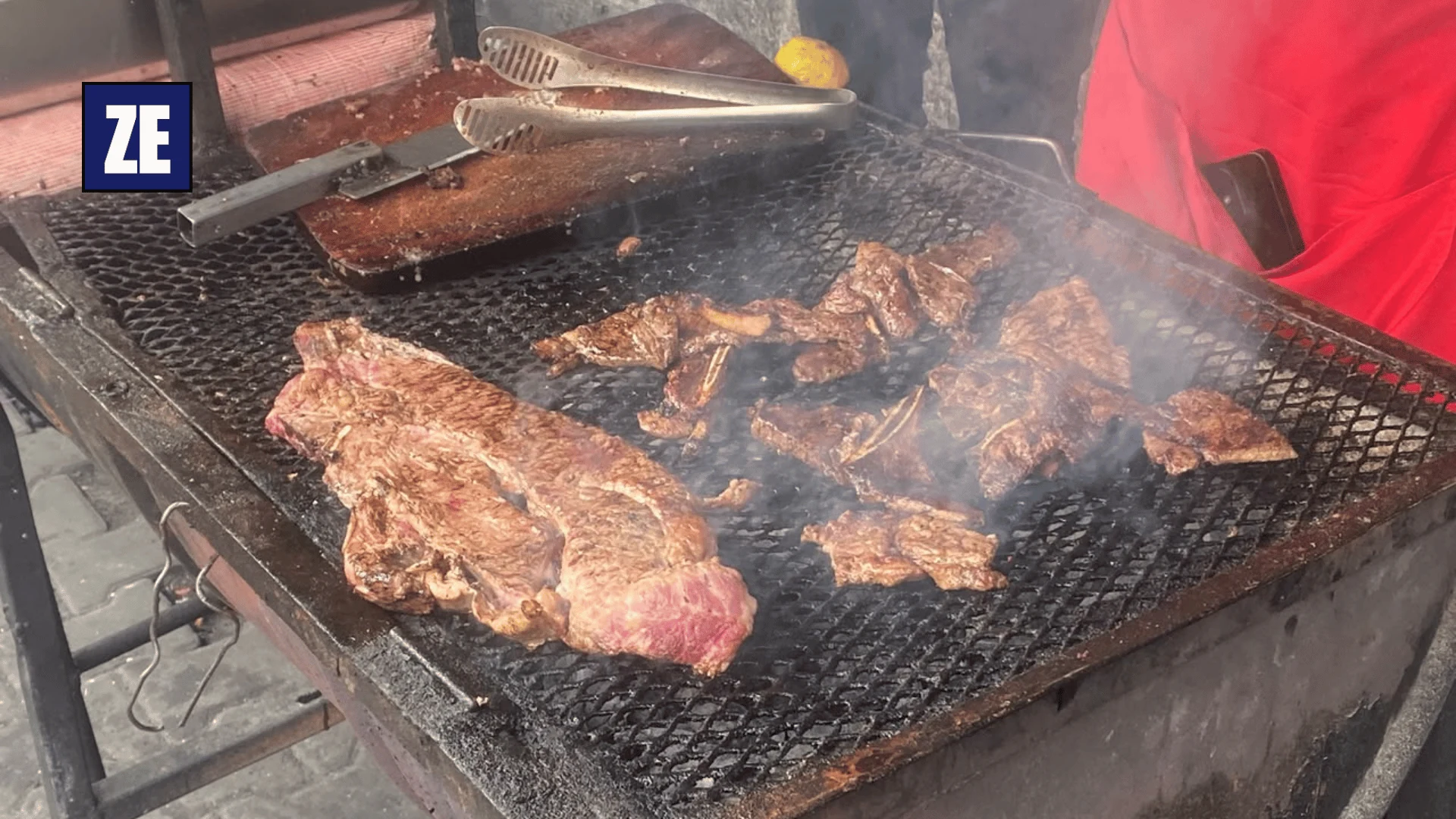 Open charcoal grill preparing meat during lunchtime at Longacres Market