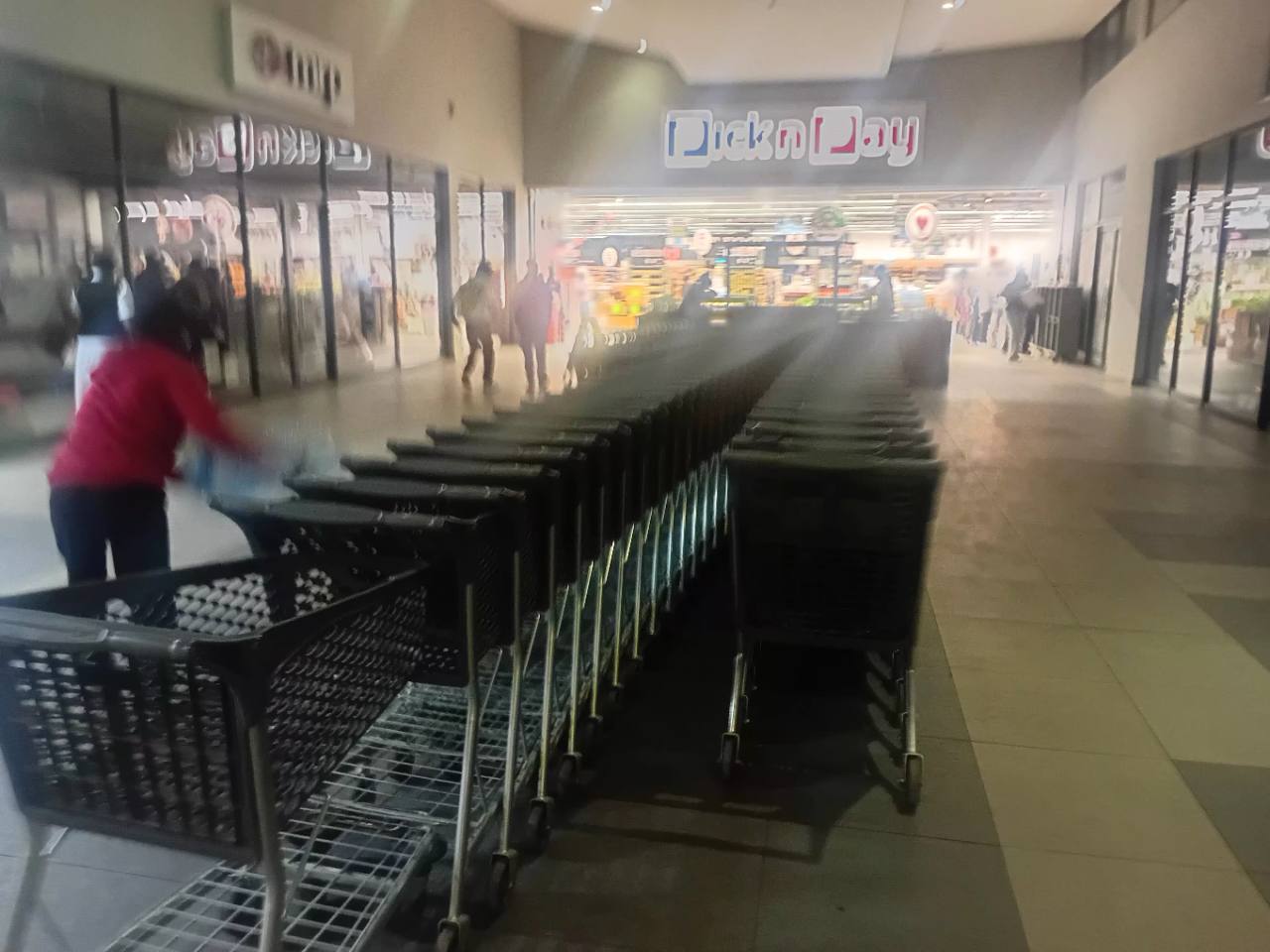 Rows of shopping trolleys and customers at the Pick n Pay entrance inside Centro Mall