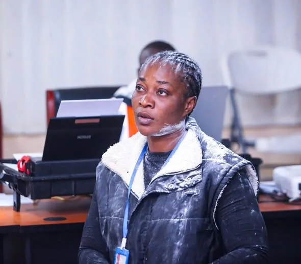 Shira Katunya Shillah speaking during a formal meeting with a laptop and office equipment behind her.