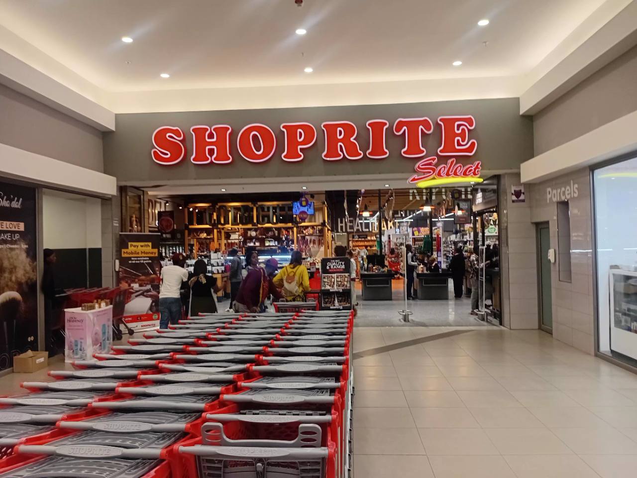 Customers and shopping trolleys at the Shoprite Select entrance inside Novare Pinnacle Mall in Lusaka