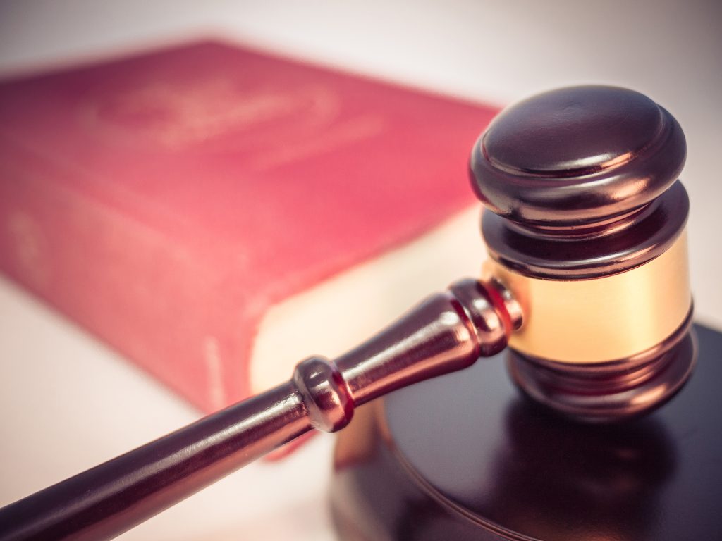A wooden judge's gavel resting on a closed law book