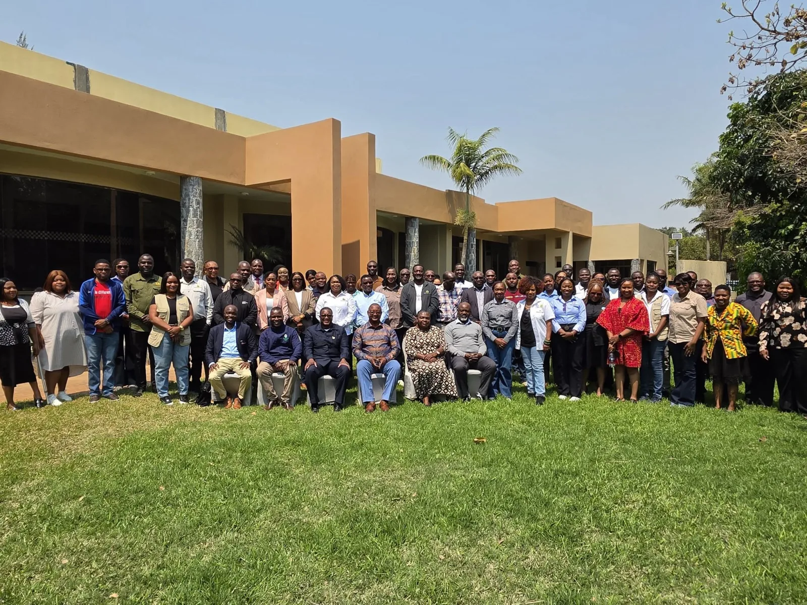 Workshop group posing outdoors in front of a building at Twangale Park, Chilanga.