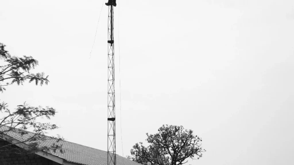 Technician mounting a wireless network antenna, illustrating mobile network infrastructure in Zambia