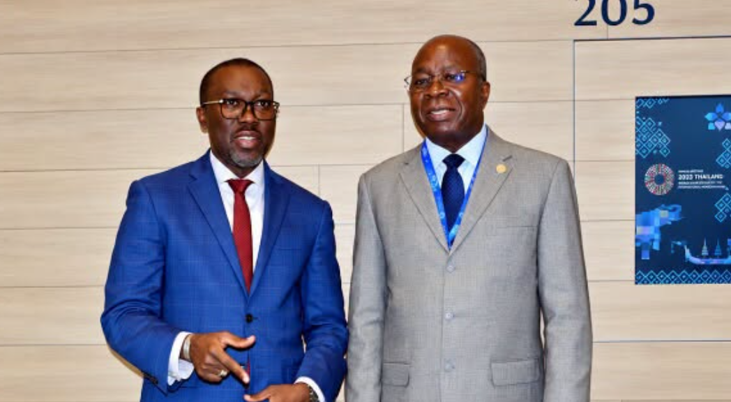Situmbeko Musokotwane and a World Bank representative outside meeting room 205 in Bangkok