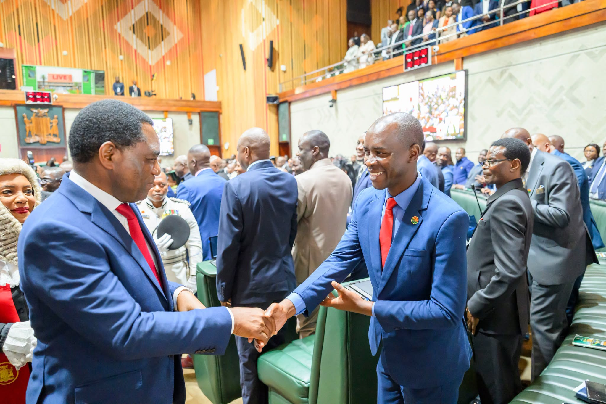 President Hakainde Hichilema greets an official in Zambia’s parliamentary chamber