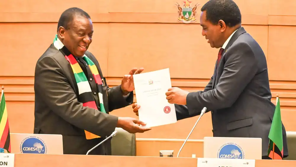 President Hakainde Hichilema hands President Emmerson Mnangagwa a certificate of title for the new COMESA headquarters in Lusaka at the 25th COMESA Summit in Harare.