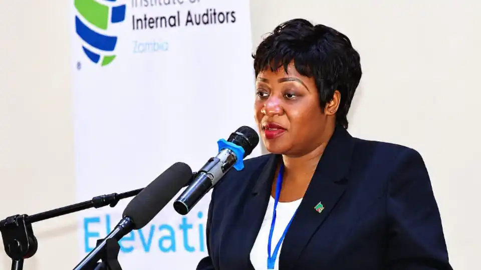 Speaker at a podium in front of an Institute of Internal Auditors Zambia banner during internal audit training at NIPA, Lusaka