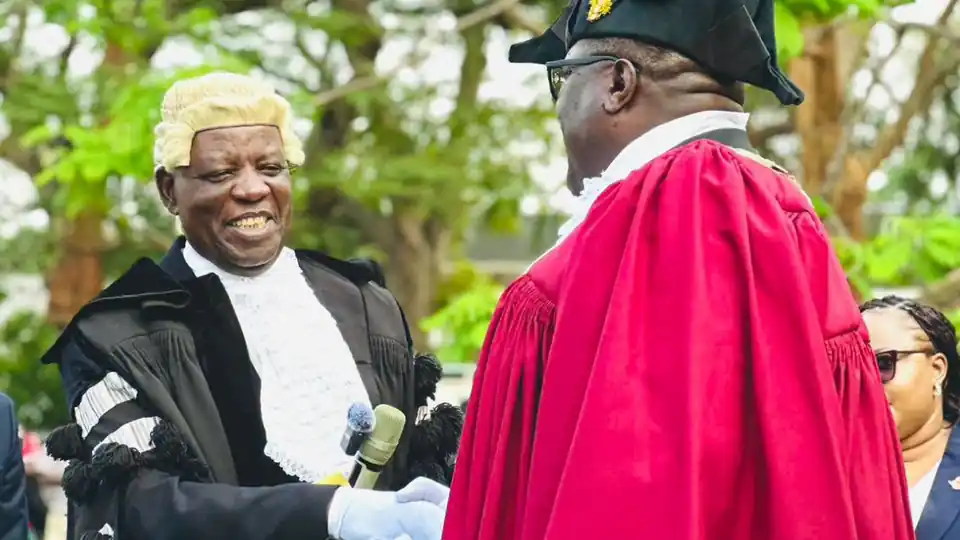 Officials in ceremonial robes and a judicial wig shake hands at the Lusaka Mayor installation ceremony