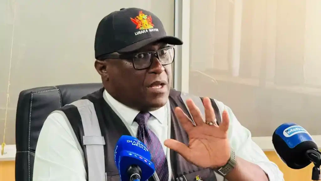 Lusaka Mayor Chitambala Mwewa, in a Lusaka Mayor cap and reflective vest, addresses journalists about Operation Clear Path against street vending