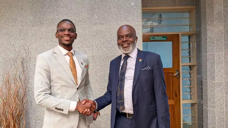Solwezi Central MP Poho Kawina shakes hands with a colleague at Parliament Buildings in Lusaka