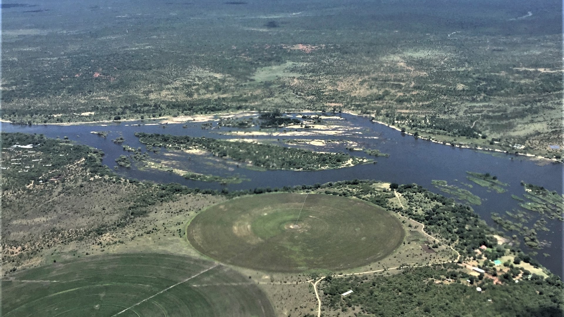 The Zambezi River winding past Sindabezi Island in Zambia with irrigation circles on the bank, illustrating water stress on rivers ahead of a super El Niño