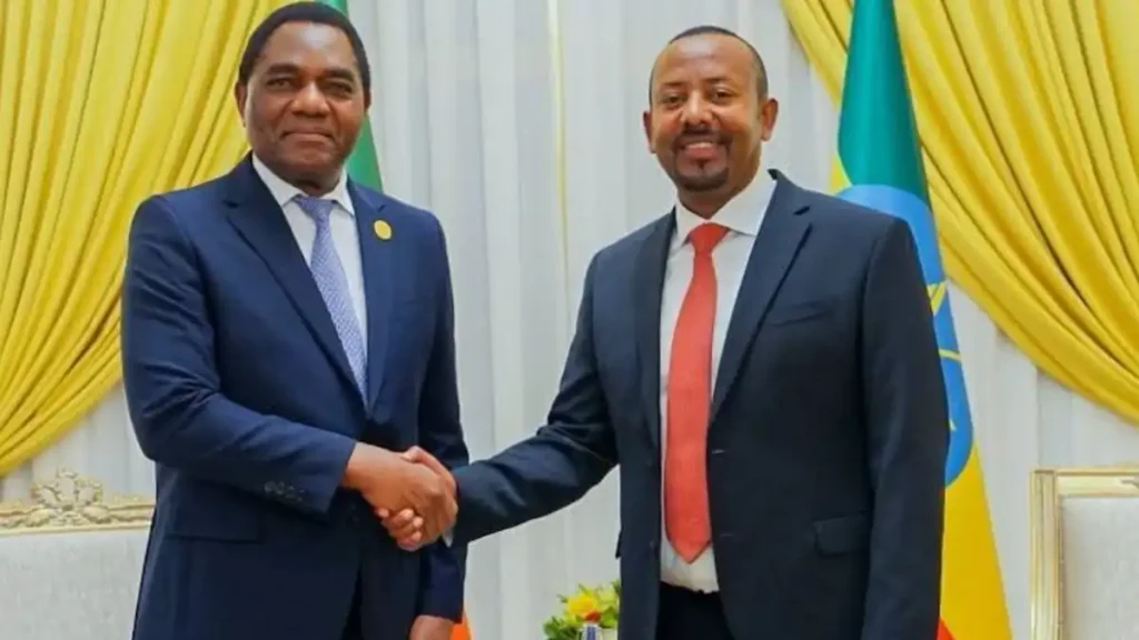 Two leaders shake hands in front of Ethiopian flags at an official meeting